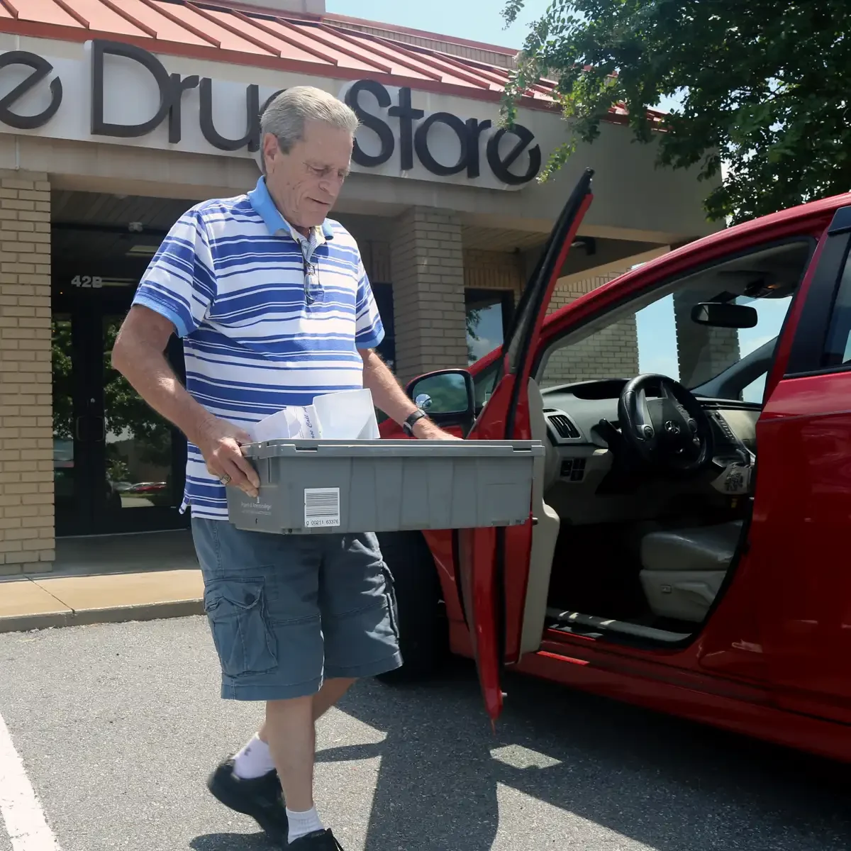 Wayne loading prescriptions into car for delivery